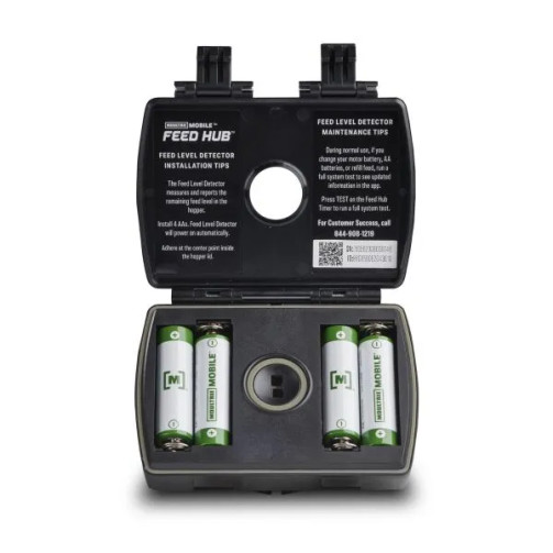 Open view of the Moultrie Universal Feed Hub Unit showing the battery compartment and printed setup instructions inside the housing.