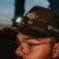 Man wearing a LuxPro LED headlamp on his cap at dusk
