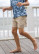 Boy running on a deck wearing Local Boy youth volley shorts in khaki