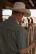 Back view of a man in a straw cowboy hat holding a rope at a ranch while wearing the Ferrell CORE short sleeve pearl snap shirt