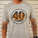 Front view of the Los Cazadores 40 Years Short Sleeve Tee in heather gray featuring the commemorative 40 Years Hunting Headquarters graphic on a male model.