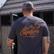 back view of a male individual wearing the los cazadores rachero tee shirt standing in front of an mb ranch king blind.
