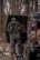 Hunter wearing the Pnuma Torrent Bibs in Caza OV camo beside a truck with a harvested buck