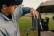 Golfer attaching a gray Turtlebox Ranger speaker to a golf cart with its magnetic mount