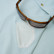Close-up of sunglasses hanging from the built-in sunglasses holder on a pale mint Poncho Original shirt