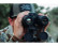 Hunter in a camo cap looking through the AGM Observir LRF 25-256 thermal and digital night vision binocular
