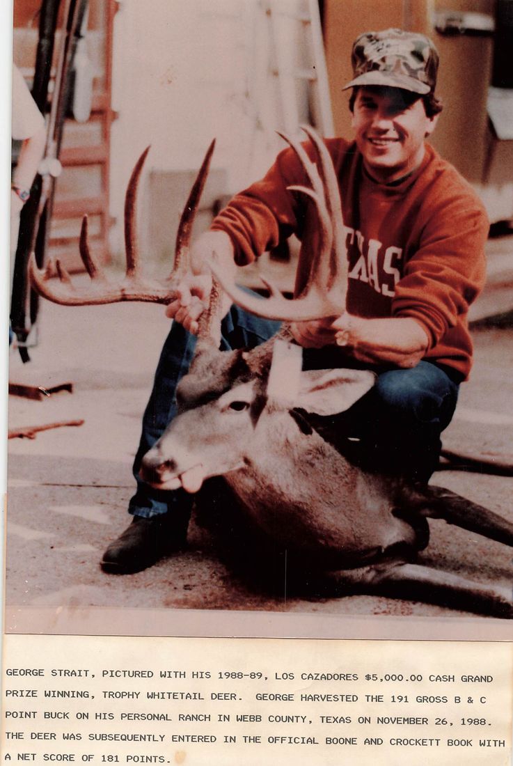 George Strait in a Texas sweatshirt and camo cap kneels behind his 1988 grand prize whitetail buck, with a typed caption below