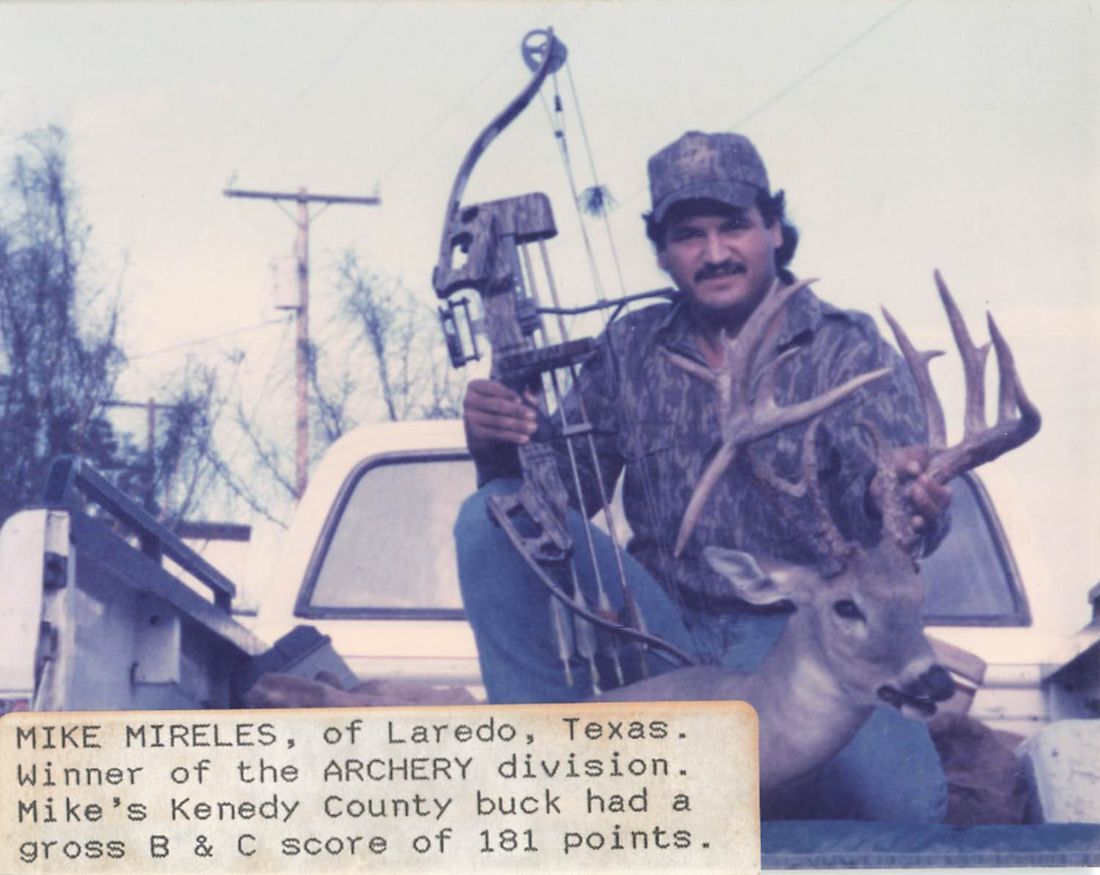 Mike Mireles sits on a truck tailgate holding his compound bow and the antlers of his archery buck
