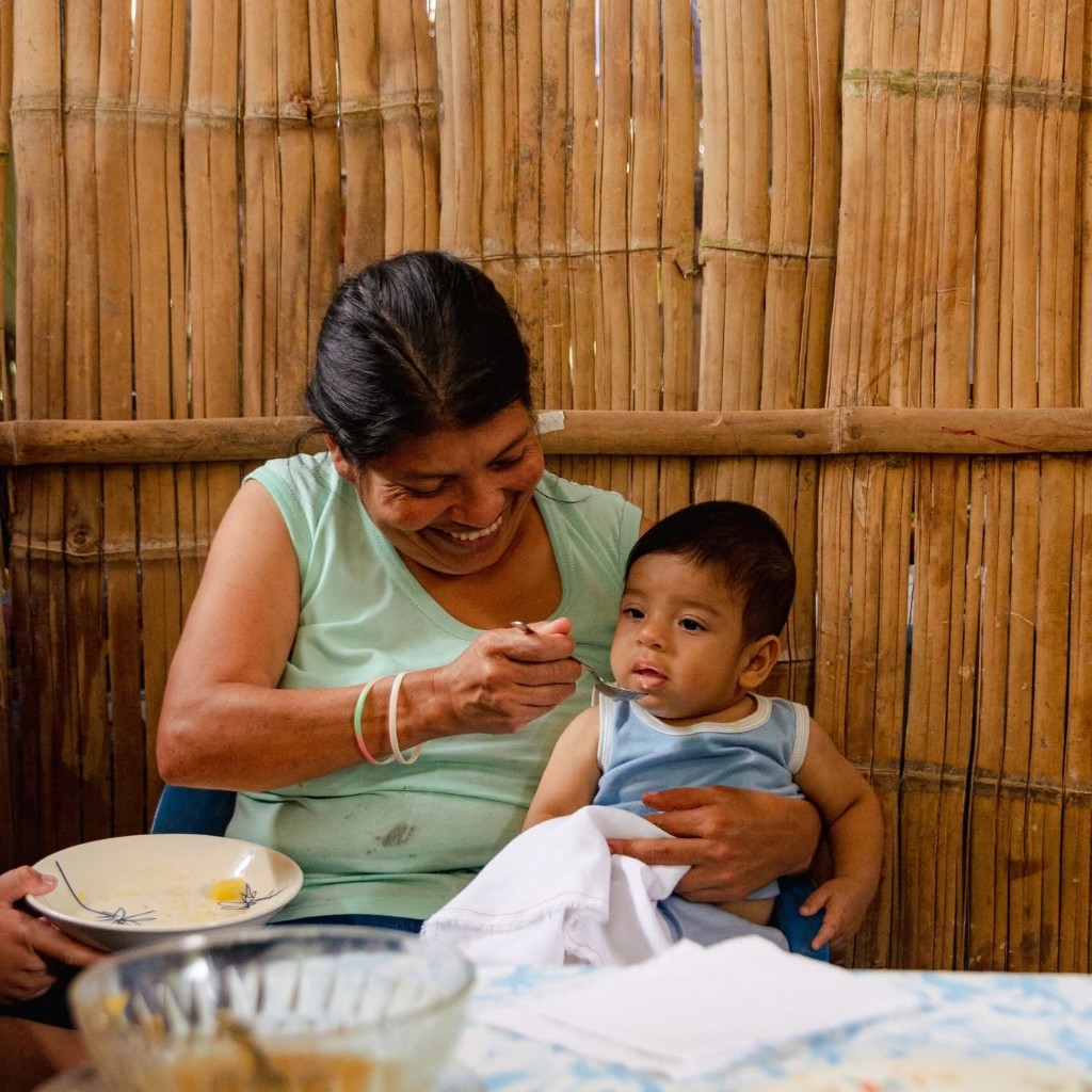 A caregiver nourishing a child through a community nutrition program