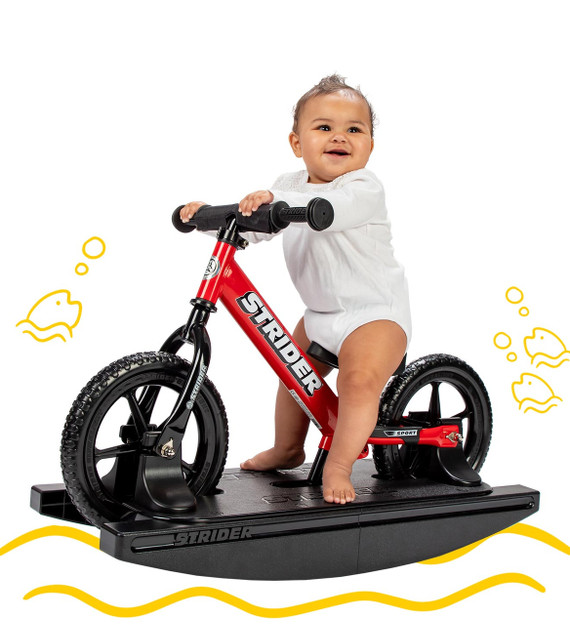 Baby sitting on a red 2-in-1 Rocking Bike with yellow digital doodles surrounding them