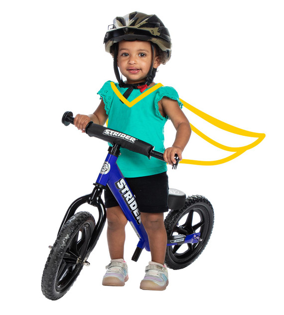 A small girl stands over a blue Strider 12 Sport balance bike