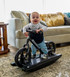 A young child giggling and playing on a Strider 12 Pro Rocking Bike