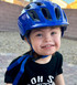 A child smiles while wearing a Blue Kali Chakra Helmet