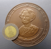 A commemorative coin for Her Majesty Queen Sri Savangavadhana's 90th birthday, made of blackened copper, 7 cm in diameter, minted in 1990 (B.E. 2533), with original box.