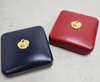 Coin box, empty box, contains 1 coin hole from the Treasury Department, available in two colors: blue and red. Leather box, beautiful condition, strong.