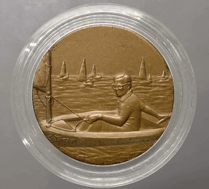 Bronze medal with black patina, depicting His Majesty the King sailing a Micro Moth, 13th Asian Games, 1998.
