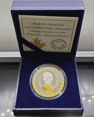 A commemorative coin celebrating the 88th birthday of King Rama IX, made of polished silver with partial plating of real gold, complete with original box and all accessories.