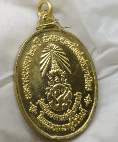 Auspicious musical medal with the royal inscription "The King plays music" on the back, made of gold-plated brass with red enamel, celebrating the 21st anniversary of the Music Association of Thailand, 1987.
