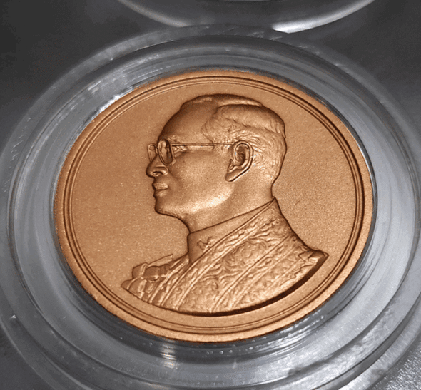 Bronze commemorative coin for the 60th anniversary of His Majesty's accession to the throne in 2006, presented in a presentation case from the Department.