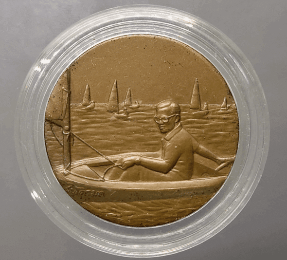 Bronze medal with black patina, depicting His Majesty the King sailing a Micro Moth, 13th Asian Games, 1998.