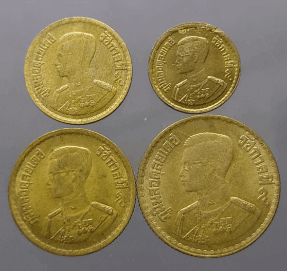 A complete set of four circulating brass coins (5, 10, 25, and 50 satang), minted in 1957 (B.E. 2500), showing signs of use.
