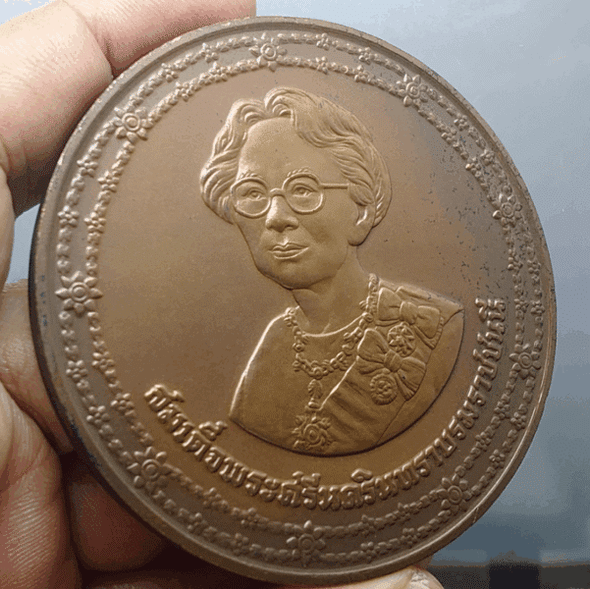 A commemorative coin for Her Majesty Queen Sri Savangavadhana's 90th birthday, made of blackened copper, 7 cm in diameter, minted in 1990 (B.E. 2533), with original box.