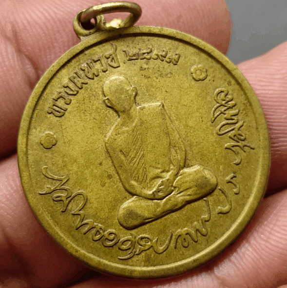 First edition of the King Rama IX ordination coin, full pagoda block, gold-plated brass, year 1965, used, guaranteed authentic, easy to see.