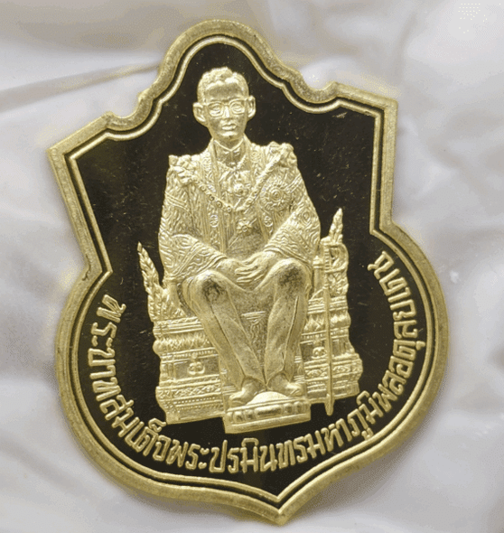 Polished gold coin of the King sitting on the throne, commemorating the 50th anniversary of the King's accession to the throne (Kanchanaphisek), created by the Ministry of Interior in 1996, with original box.