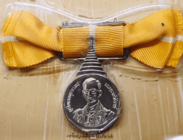 A commemorative coin decorated with a ribbon, from the Royal Coronation Ceremony of His Majesty King Rama IX, 1988. Rare, few made (female model).
