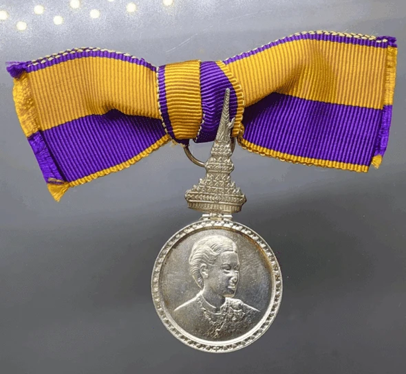 A commemorative medal decorated with a ribbon, the Royal Ceremony of the Coronation of Her Royal Highness Princess Maha Chakri Sirindhorn, 1977, "Female Model"