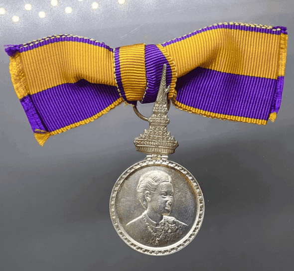 A commemorative medal decorated with a ribbon, the Royal Ceremony of the Coronation of Her Royal Highness Princess Maha Chakri Sirindhorn, 1977, "Female Model"