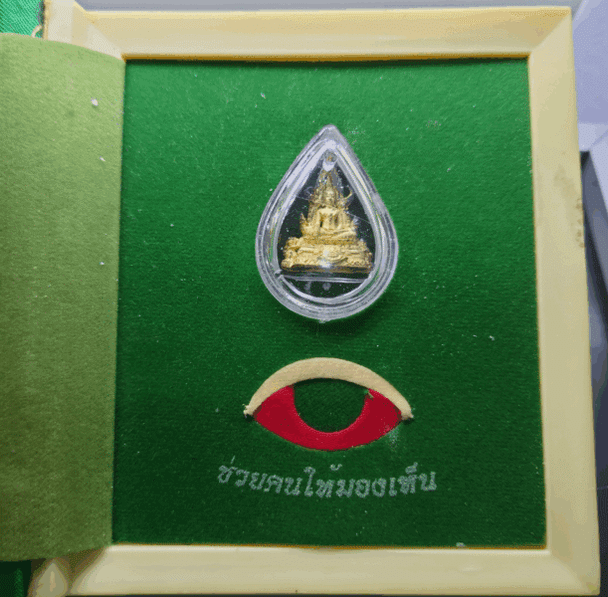 Phra Phuttha Chinnarat amulet, silver plated with gold, small size, commemorative edition for the 6th cycle birthday of King Rama IX, created by the People's Eye Protection Foundation in 2542 BE (1999 CE), with original box.