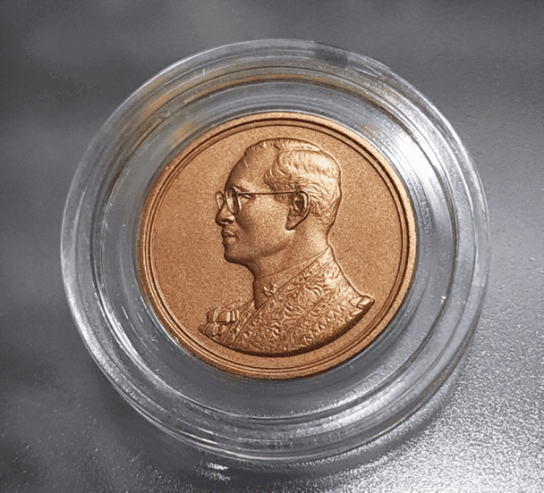 Bronze commemorative coin for the 60th anniversary of His Majesty's accession to the throne in 2006, presented in a presentation case from the Department.