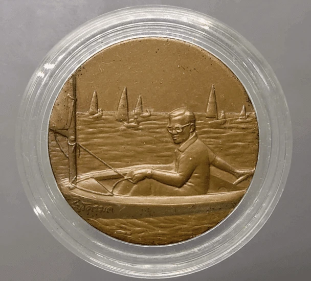 Bronze medal with black patina, depicting His Majesty the King sailing a Micro Moth, 13th Asian Games, 1998.