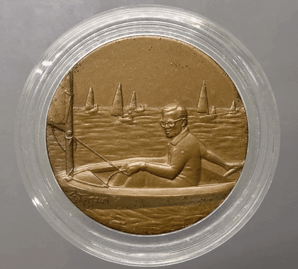 Bronze medal with black patina, depicting His Majesty the King sailing a Micro Moth, 13th Asian Games, 1998.