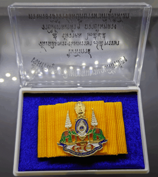Golden Jubilee pin on yellow silk cloth, created on the occasion of the 75th birthday of King Rama IX in 2002, with original case, guaranteed authentic.