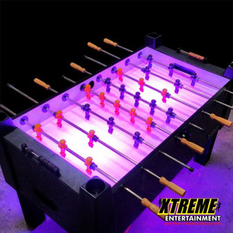 "4-player LED foosball table glowing with lights at a modern party setup"