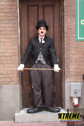 "Charlie Chaplin impersonator entertaining guests with silent comedy at a vintage-themed event"