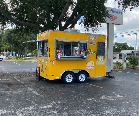 "Catering food trailer offering gourmet meals at an outdoor event"