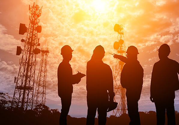group of technicians inspect cell tower site