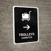 Trolleys With Right Arrow Black Bilingual Spanish Portrait - Wall Sign