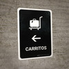 Trolleys With Left Arrow Black Spanish Portrait - Wall Sign Trolleys With Left Arrow Black Spanish Portrait - Wall Sign