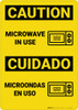 Caution: Microwave in Use Bilingual Spanish - Wall Sign