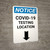 Notice: COVID-19 Testing Location Down Arrow Portrait - Wall Sign