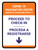 Covid-19 Vaccination Center: Proceed To Check In Down Arrow Bilingual Spanish Portrait - Wall Sign