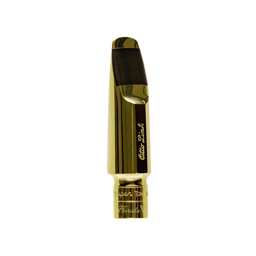 Gold-colored Otto Link saxophone mouthpiece with black tip and engraved branding, displayed on a flat surface for clear view of design and finish.