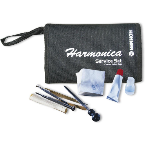 A black nylon case with "Harmonica Service Set" written on it, containing tools like brushes and tubes.
