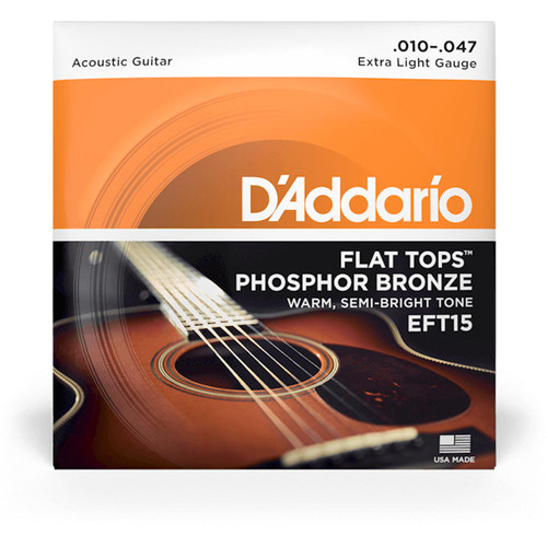 A close-up of D'Addario EFT15 Flat Tops Phosphor Bronze Acoustic Guitar Strings packaging with a guitar visible in the background.