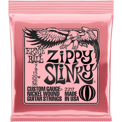 A close-up of Ernie Ball Zippy Slinky guitar strings packaging with an eagle logo on a pink background.