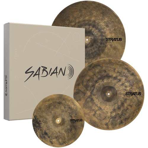 A square, tan-colored Sabian product box standing upright next to a collection of three raw-finish Sabian Stratus Dry cymbals of varying sizes, including hi-hats, a crash, and a ride.